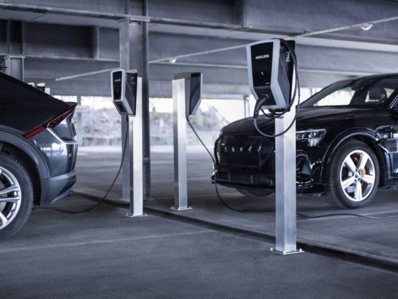 E-Auto-an-Ladestation.jpg Ein schwarzes E-Auto parkt auf einem Parkplatz und wird geladen